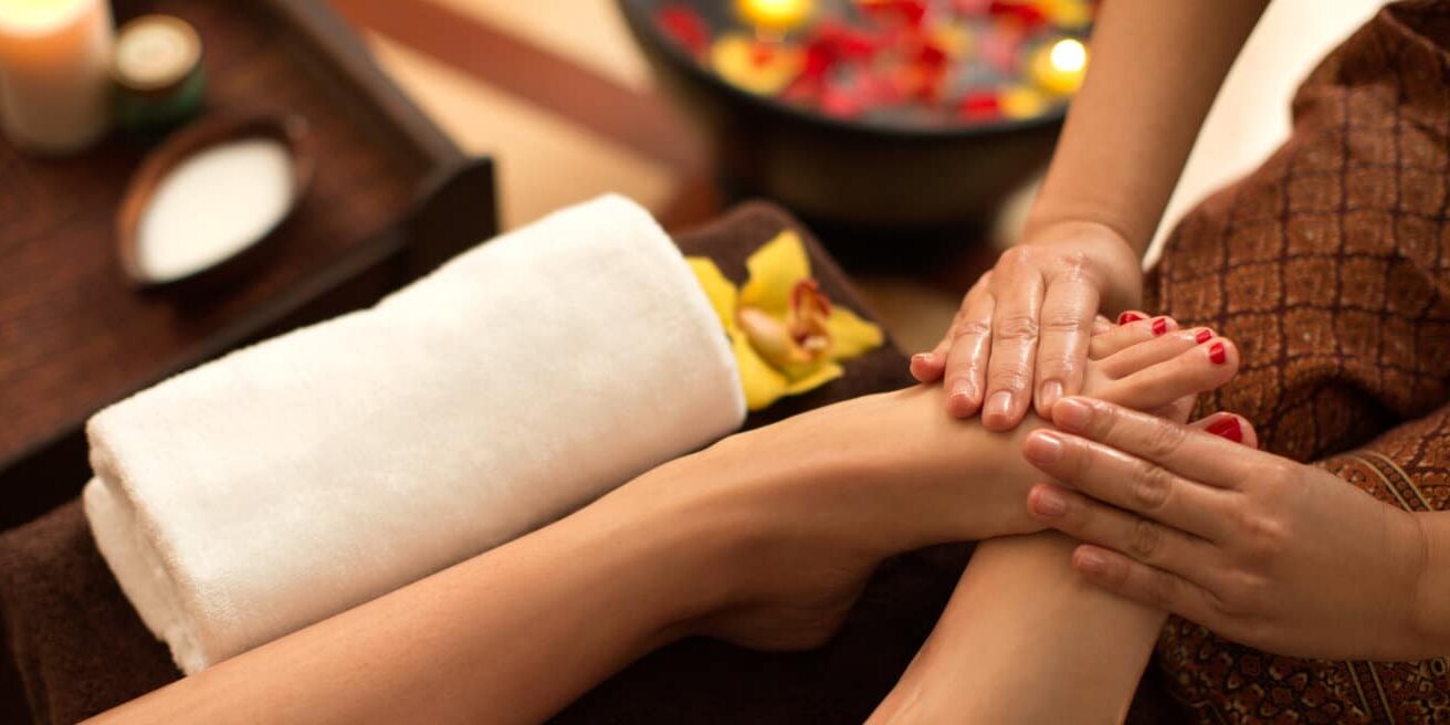Young woman enjoying foot massage in Thai SPA.