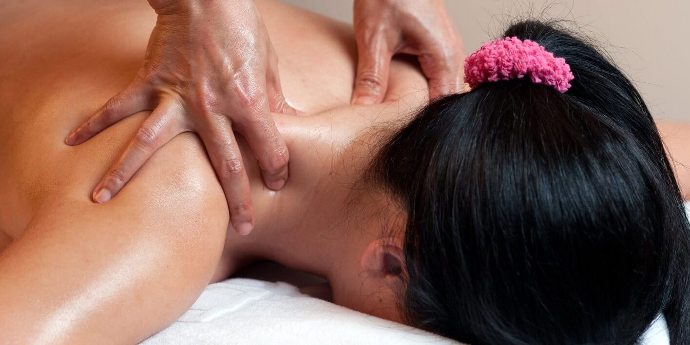 Thai massage therapists doing a neck massage for a female client.